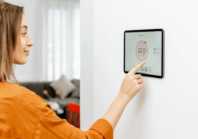 femme en train de régler le thermostat de son chauffage